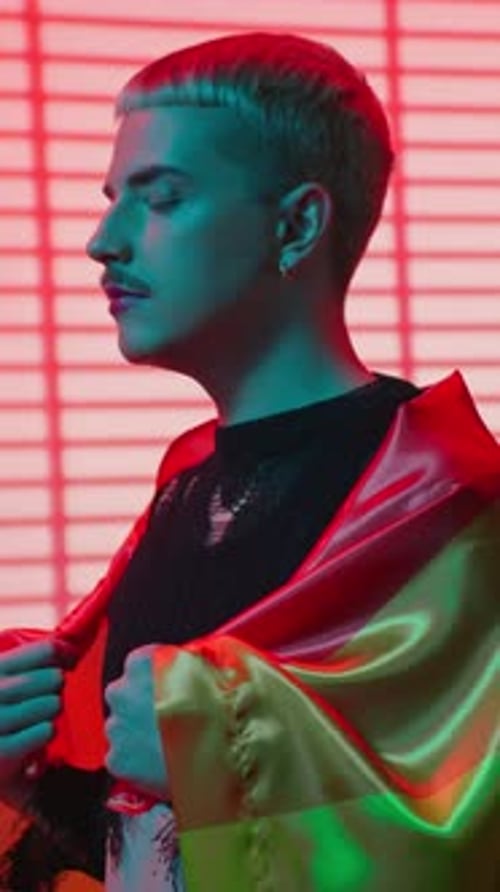 Young Adult Poses with Pride Flag in Studio