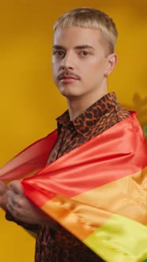 Studio Shot of Confident Man with Moustache in Gay Rainbow Flag Looking at Camera