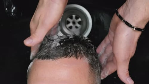 Man Getting Hair Washed With Shampoo in Salon