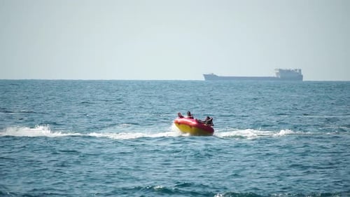 People Enjoying Thrilling Tube Ride Pulled by Jet Ski