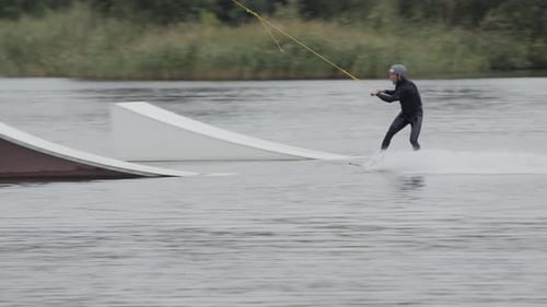 Young Adult Wakeboarding and Performing a Trick on Lake