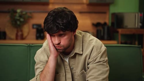 Man Looking Thoughtful on Couch at Home