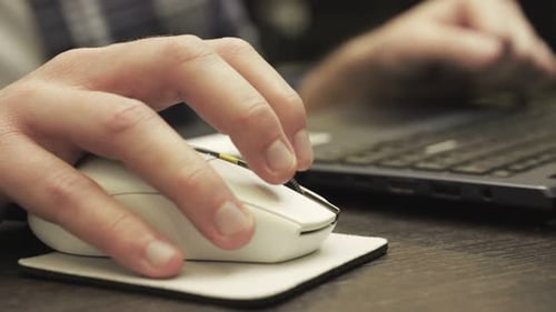 Homme travaillant avec un ordinateur portable tout en cliquant sur la souris Concept de technologie de travail en ligne