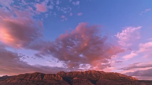 Sunset timelapse as clouds and mountain glows