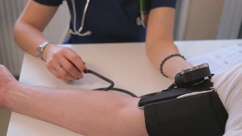 Nahaufnahme eines Arztes, der den Blutdruck eines Patienten misst