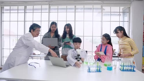 Atmosphere in elementary school science classrooms. Science teacher is training students to experime