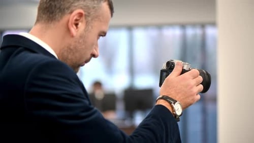 Professioneller Fotograf, der in einem Büro mit einer Kamera auf einem Stativ fotografiert