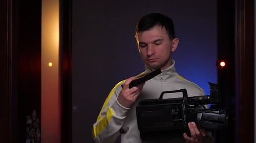 Homem inserindo cassete Vhs em uma antiga filmadora Vhs vintage