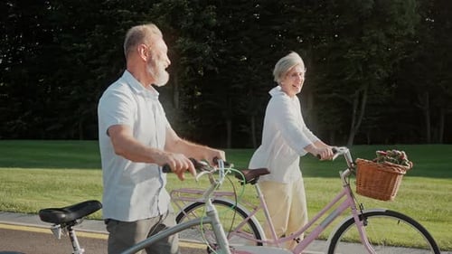 Couple of Mature Age Taking Leisure Walk After Riding Bike
