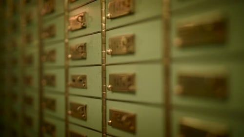 Line of Green Lockers with Gold Handles on Wooden Wall