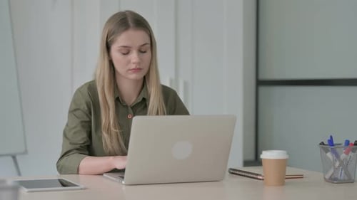 Woman Coughing While Using Laptop at Desk
