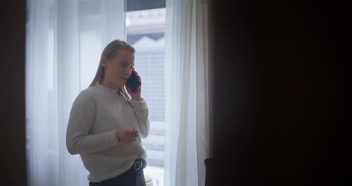 Woman Talking on a Cellphone Indoors During the Day