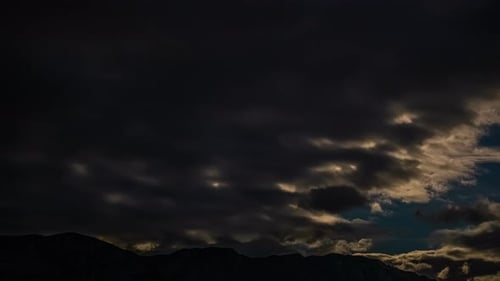 Zeitraffer Blauer Abendhimmel, bedeckt von stürmischen schwarzen Wolken, Wind, Mondlicht