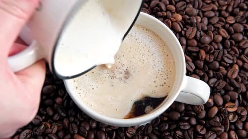 Milk Pouring into a Mug of Hot Coffee