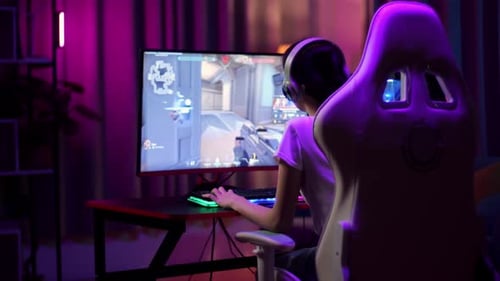 Gamer Plays Video Games at Neon Lit Computer