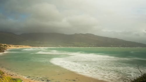 Dunkle Regenwolken ziehen über exotische Küste und Insel, Zeitrafferansicht