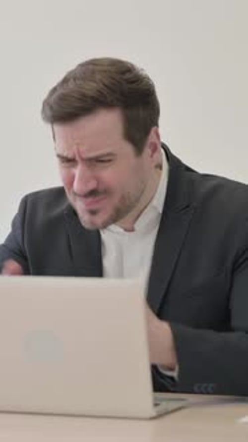 Businessman Reacting to Loss While Working in Office, vertical video