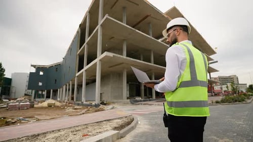 Bauingenieur mit Laptop auf der Baustelle