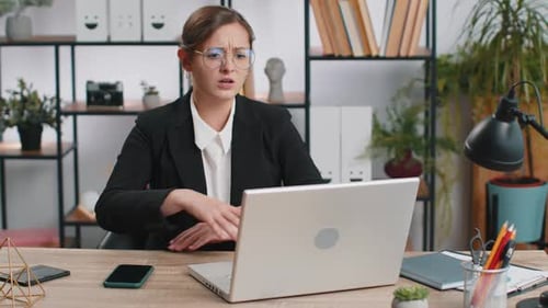 Worried Woman at Desk with Laptop in Office