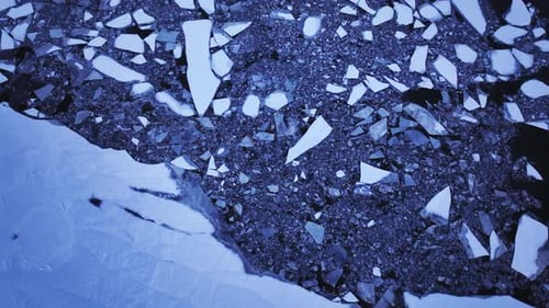 Aerial perspective of massive ice blocks drifting in the water.