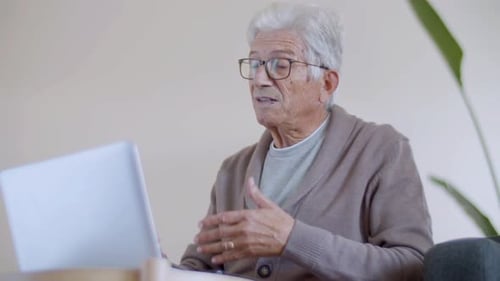 Senior Man Video Calling with Laptop Indoors