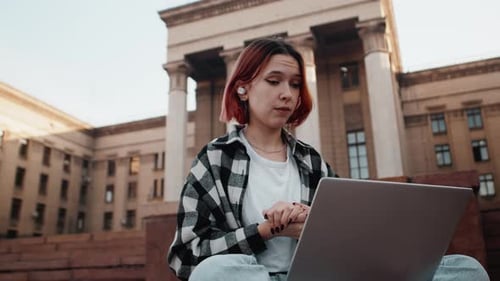 College Student Attends Meeting on Laptop Outdoors