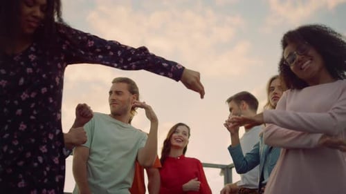 Closeup Multiethnic People Rocking At Sunset Rooftop Party. Bottom View Happy Friends Hanging Out...