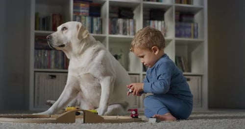 Child and Dog Playing Trains at Home
