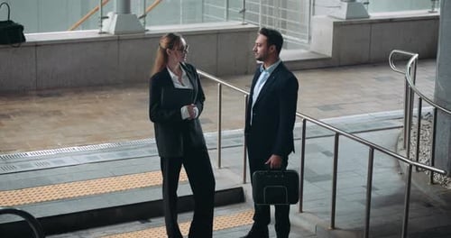 Business partners discussing corporate plan while standing at modern transit hub