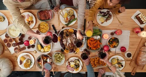 Overhead Shot of Friends Toasting Drinks at Dinner Table