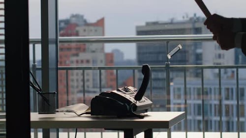 Man Hitting Landline Phone Using Bat Inside Tall Glass Tower Workplace Closeup