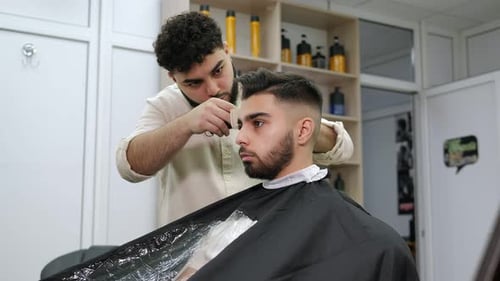 Barber Trimming Hair in a Modern Barbershop
