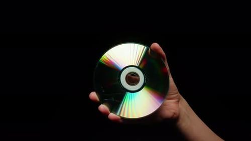 CD Disk in Hands on Black Background Closeup Old Vintage Disks for DVD Player or Computer Music