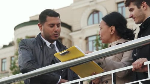 Trois professionnels s'engagent dans une discussion animée sur des documents importants