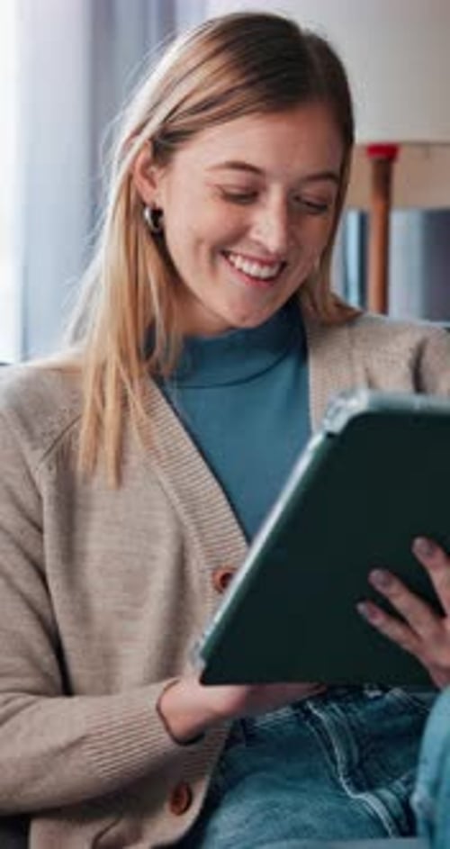 Young Woman Using Tablet Indoors in Natural Light
