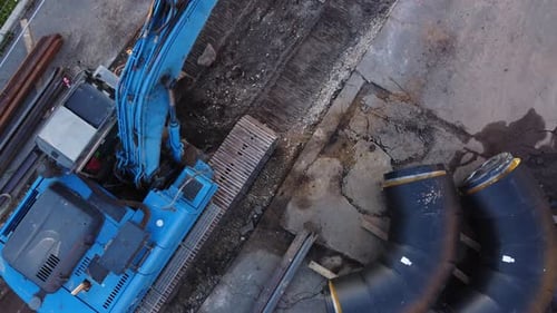 Blue Excavator Working on Urban Construction Site