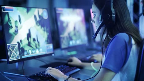 Focused Woman Gaming on Computer with Headset