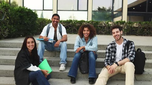 Multiracial college students studying and discussing together outdoors.