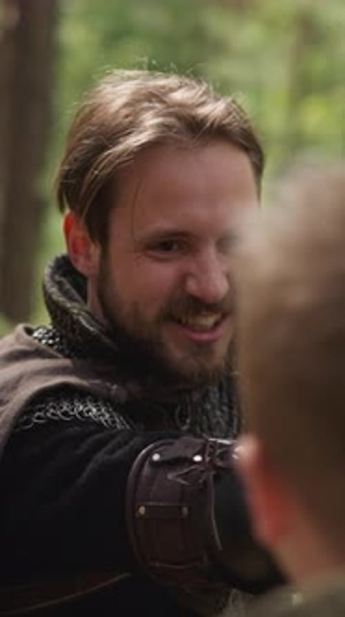 Man in Knight Armor Fights with Boy on Swords at Camp
