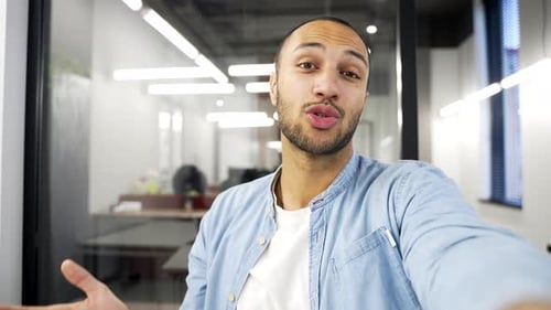 POV Smiling african american businessman talking on video call using phone in a business office.