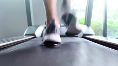 Man running on treadmill in gym.