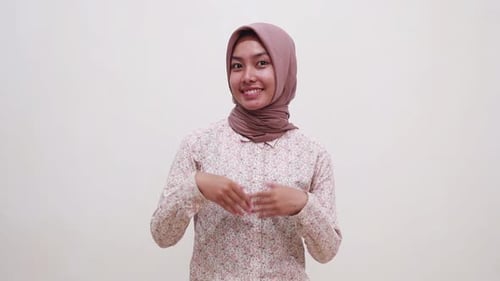 Happy young asian muslim girl standing while presenting both sides. Isolated on white