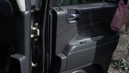 Man Cleaning Black Car Door Interior With Cloth