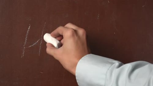 Hand Writes Hello with Chalk on Board
