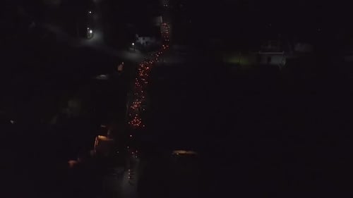 Religious event in the night time. Candles traveling through the street. Ritualistic looking event.