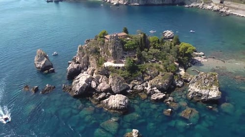 Circular drone shot around Isola Bella in Taormina, Sicily.