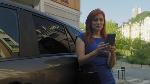 Woman Using Smartphone Beside Urban Vehicle