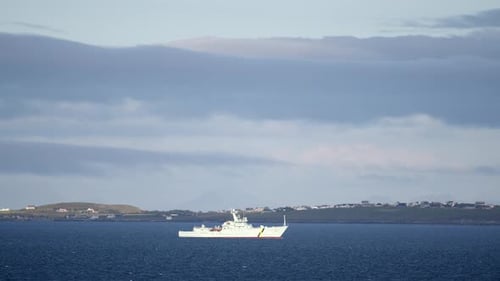 A Navy Coastguard fisheries protection vessel drives through rough seas. The Point peninsula is visi