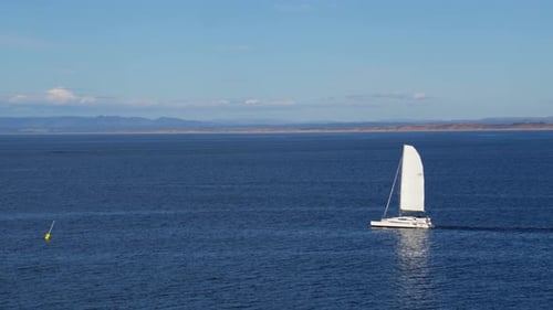 Sailboat glides across sparkling monterey bay California waters captured by drone
