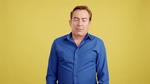 Man Looking Down in Blue Shirt on Yellow